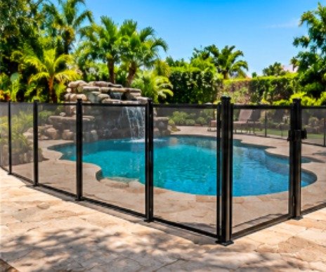 After: freeform pool with a rock waterfall with a black mesh removable pool fence