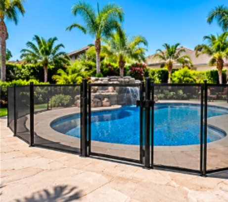 After: kidney-shaped pool with a stone grotto with a black mesh removable pool fence
