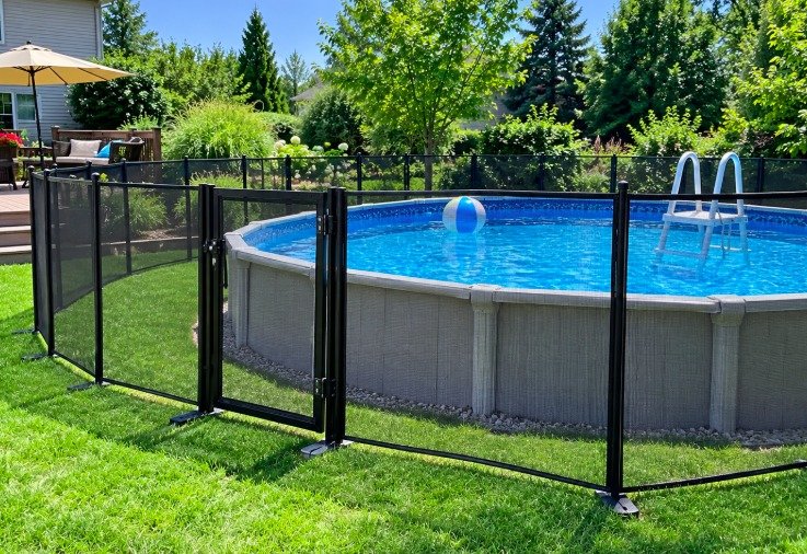 Portable mesh fence with a gate around an above-ground pool on a lawn
